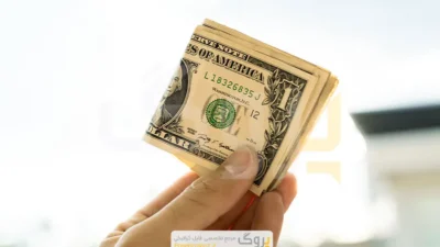 عکس استوک مردی که اسکناس‌های دلار آمریکا را در دست دارد